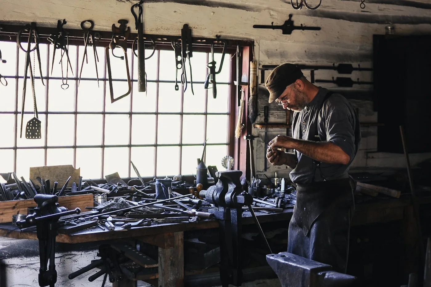 Artisan dans son atelier, établi et outils suspendus au mur