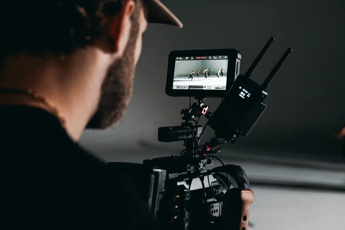 Vidéaste cadrant un plan sur un moniteur de tournage