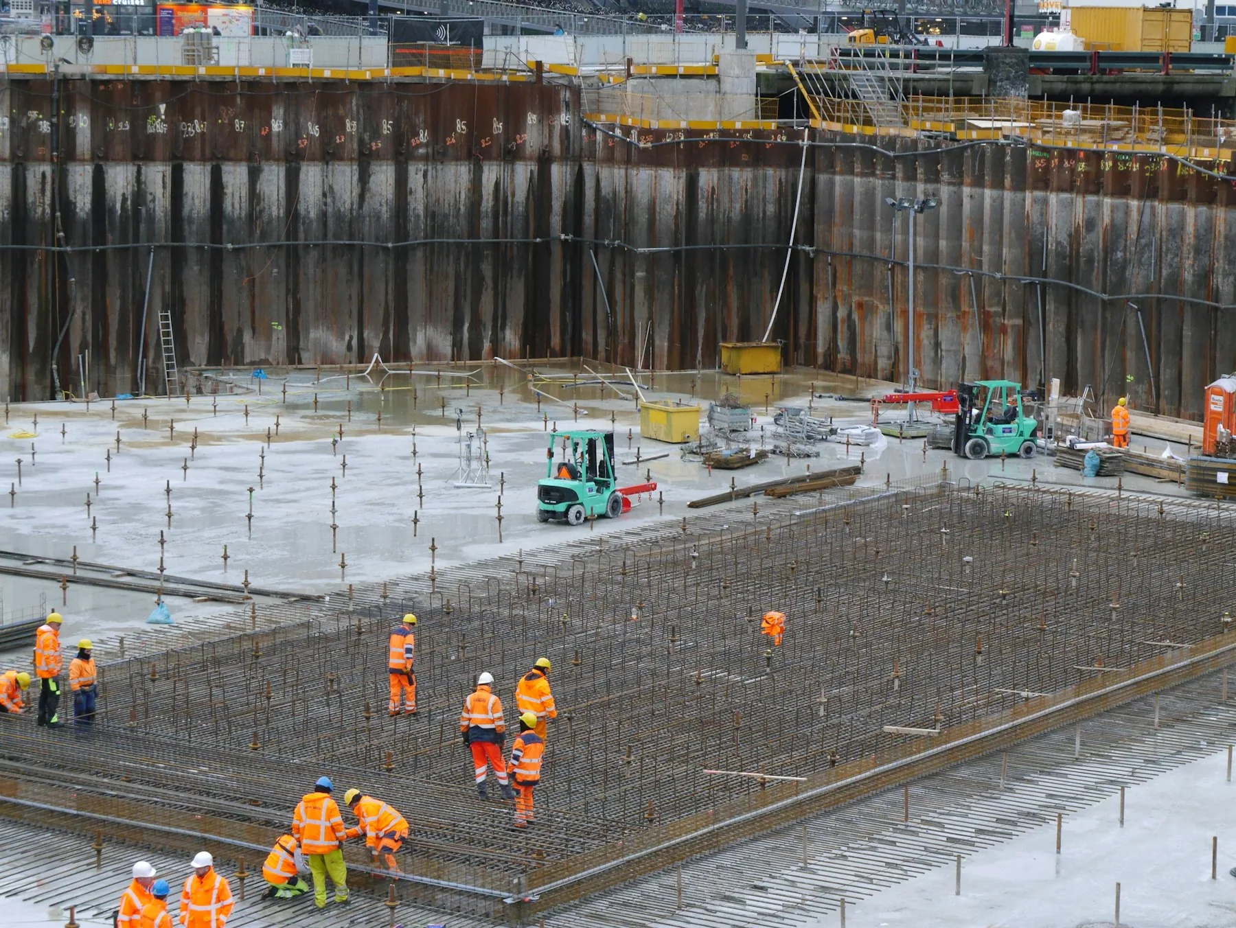Vue large d'un chantier de construction avec plusieurs équipes au travail