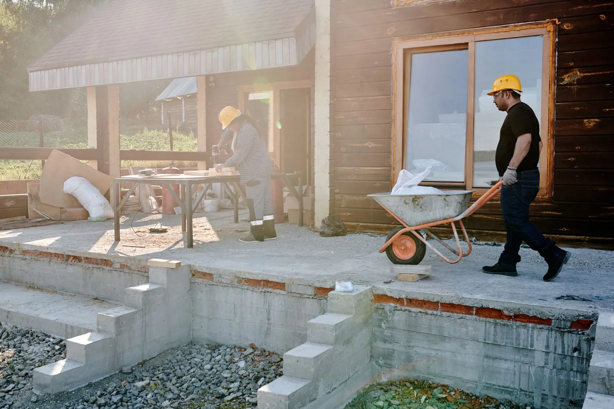 Deux artisans au travail sur le chantier d'une maison, en fin de journée