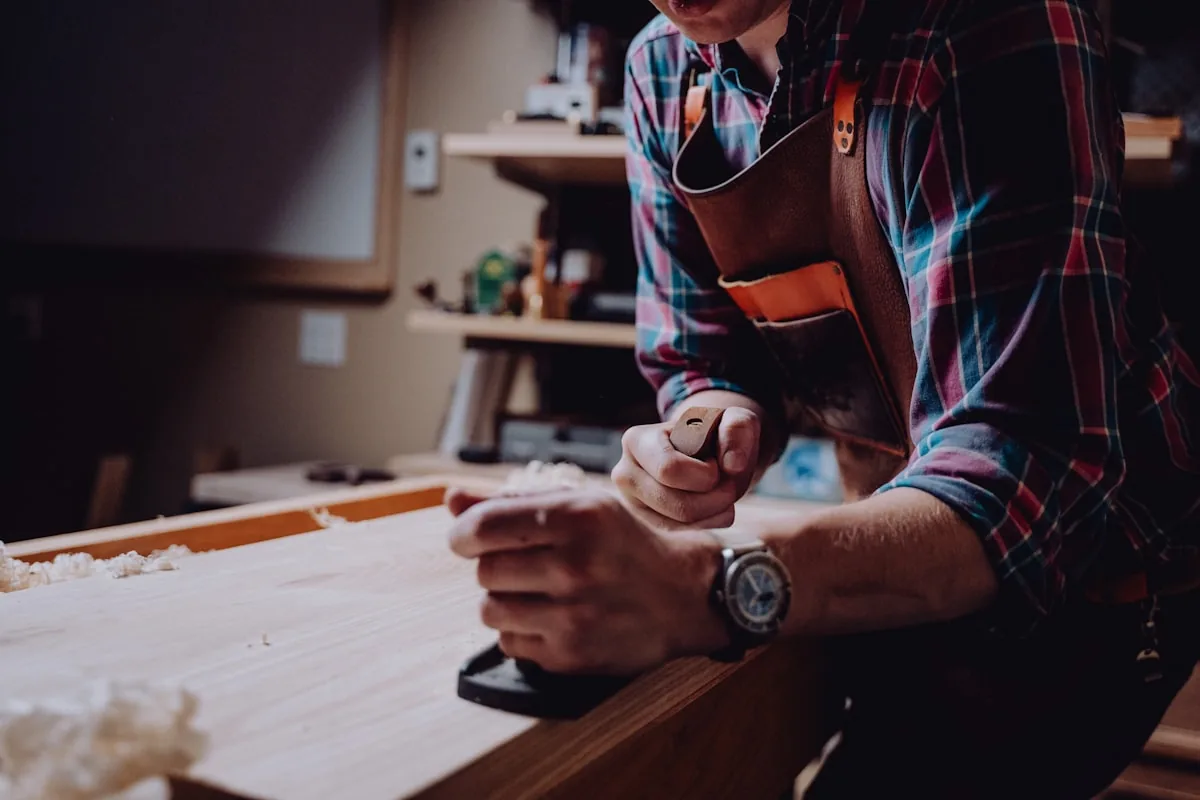 Menuisier au travail sur un plan de travail en bois